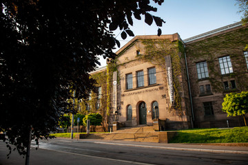 Fasaden av Nasjonalbiblioteket, en stor murbyggning, med brede trapper og klatreplanter oppetter veggene. 