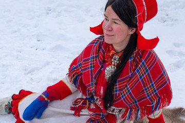 Kvinne utendørs i snøen i samisk kofte
