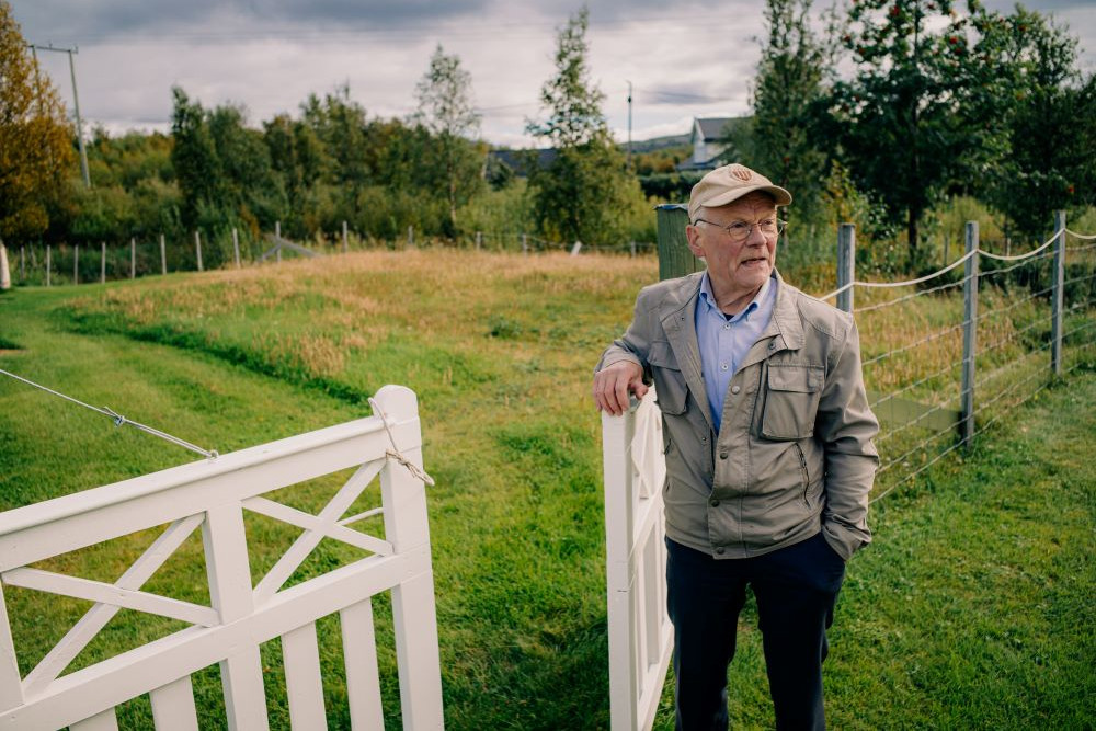 Arvid Petterson står utenfor sitt eget hus. Bak ham er en viltvoksende del av hagen som han tar vare på som et minnested. Det var akkurat her huset som ble nedbrent av tyskerne, stod.